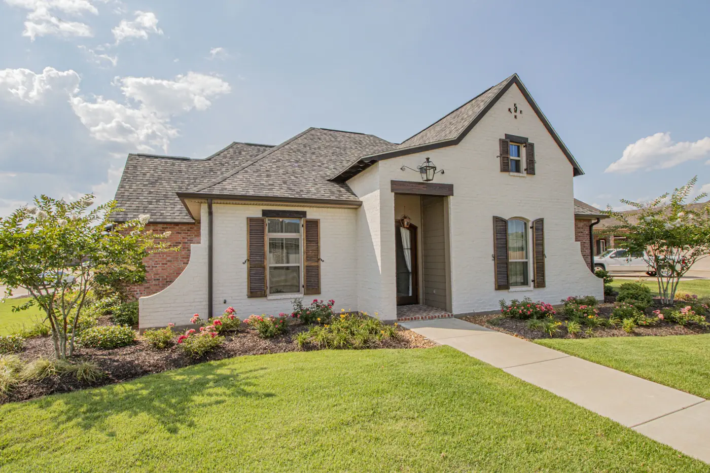 Traditional white brick house exterior with landscaping